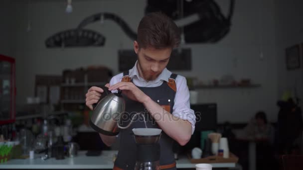 从茶壶到酿造杯中倒入开水的男咖啡师的近距离查看 — 图库视频影像