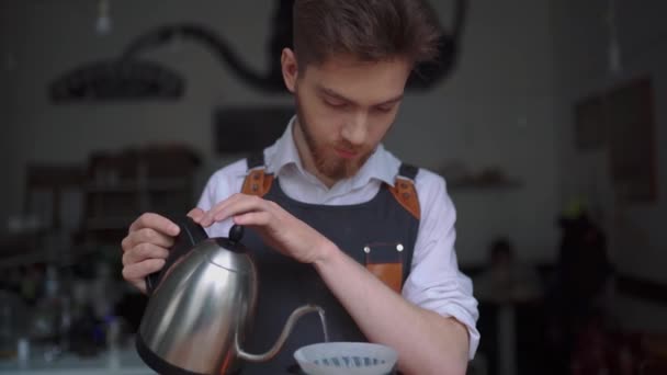 从茶壶到酿造杯中倒入开水的男咖啡师的近距离查看 — 图库视频影像