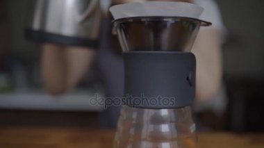 Kadın barista çaydanlık bardak bira için kaynar su dökülen görünümünü