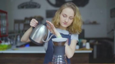 Kadın barista çaydanlık bardak bira için kaynar su dökülen görünümünü