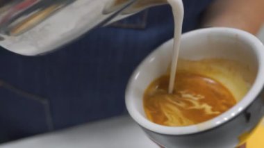 Buharda pişmiş süt Cappuccino yapmak için kahve dökülür kadeh yukarıya kapatmak