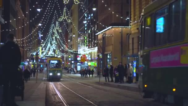 Helsinky, Finsko - 20. prosince 2018 - Ulice Aleksanterinkatu o Vánocích s tramvají a lidmi — Stock video