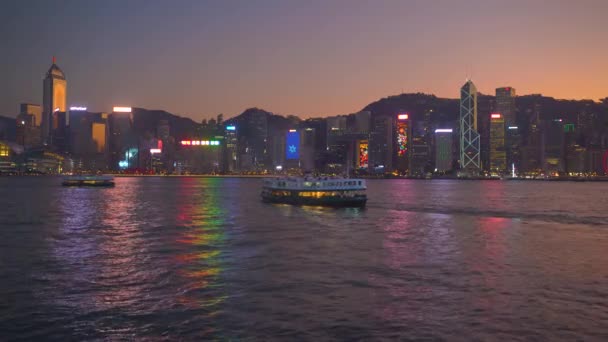 Hong Kong, Čína - 06. 12. 2019: 4k Victoria Harbour s panorama a turistickými loděmi v noci — Stock video