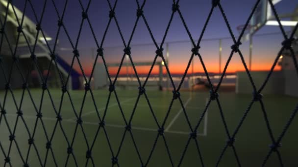 Empty Street Cancha de baloncesto por la noche a través de valla de alambre de malla en 4k — Vídeo de stock