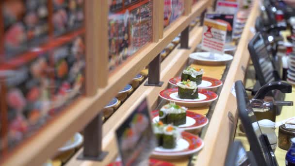Sushi restaurant ferroviaire avec plaques alimentaires japonaises tournantes en 4k — Video