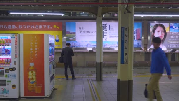Осака, Япония - NOV 05, 2019: Люди ждут поезд JR на станции в 4k — стоковое видео
