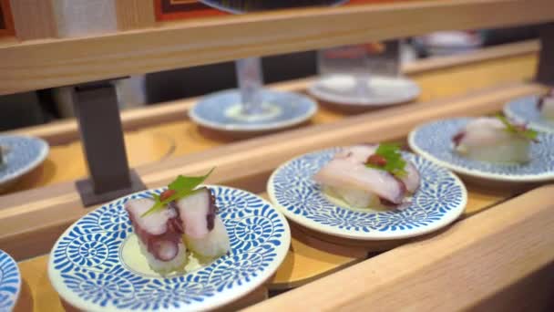 Sushi restaurante ferroviario con platos de comida japonesa giratoria en 4k — Vídeos de Stock