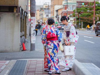 Kyoto, Japonya - 11 Nisan 2019: Gion ilçesindeki Shijo-dori caddesinde ulusal kimono kostümlü Japon kızlar yürüyor