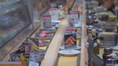 Sushi rail restaurant with rotating Japanese food plates in 4k