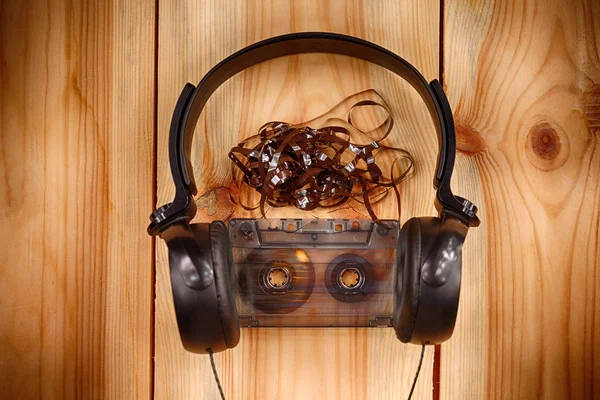 vintage old film music cassette with headphones on a wooden background, music background, music lovers, close up