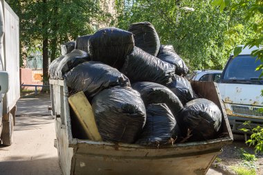 Çöplerle dolu siyah plastik torbalar, çöp toplama konsepti, sokak temizliği, atık geri dönüşümü