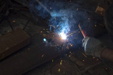 Kaynak makinesinin işi kaynak makinesinin elinde kaynak kıvılcımları, endüstriyel arka plan