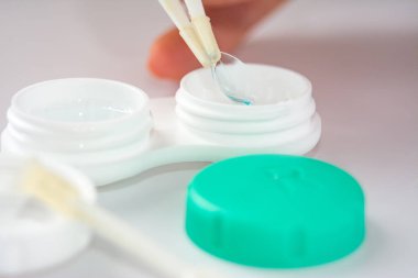 Hafif arka planda cımbız bulunan yumuşak kontak lensler ve lensler için konteyner