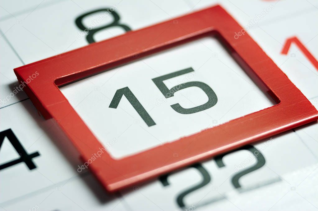 fifteenth of the month highlighted on the calendar with a red frame close-up macro, mark on the calendar, fifteenth date