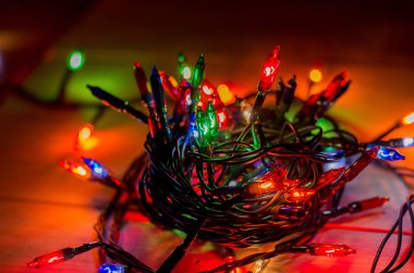 Karanlık bir odada Noel çelengi ışıkları, yanan ampuller, kış Noel havası.