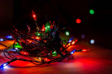 Karanlık bir odada Noel çelengi ışıkları, yanan ampuller, kış Noel havası.