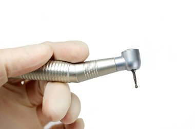 Dişçinin elindeki diş teli beyaz arka planda izole edilmiş. Yakın plan, diş matkabı, burr.