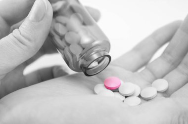 Siyah ve beyaz renkli bir hapın tek vurgulanmış hali, ilaç konsepti herkes için değil, ilacın yüksek maliyeti.