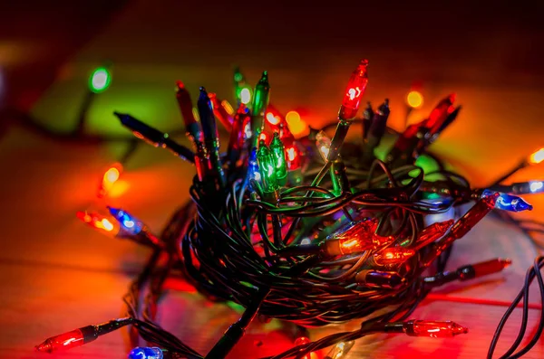 Karanlık bir odada Noel çelengi ışıkları, yanan ampuller, kış Noel havası.