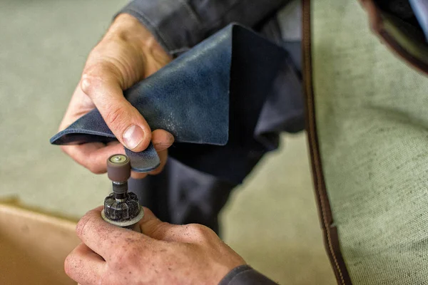 leather worker processes the product, polishes the edges