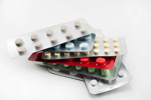 丸い多色の錠剤を持つ水疱光の背景に赤黄色の青白クローズアップ 抗生物質 ビタミン 鎮痛薬 抗ヒスタミン薬 抗アレルギー — ストック写真
