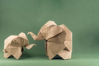 Origami fili ve bebek fil yeşil arka plan, kağıt ve orman koruma kavramı üzerine Kraft kağıdından yapılmış, kağıt tasarrufu ormanı, maketi, spac 'ı kopyalama