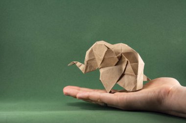 Origami fili ve bebek fil yeşil zemin, kağıt ve orman koruma kavramı üzerine el işi kağıdından yapılmış, kağıt tasarrufu, ormanı, maketi, alanı kopyalama