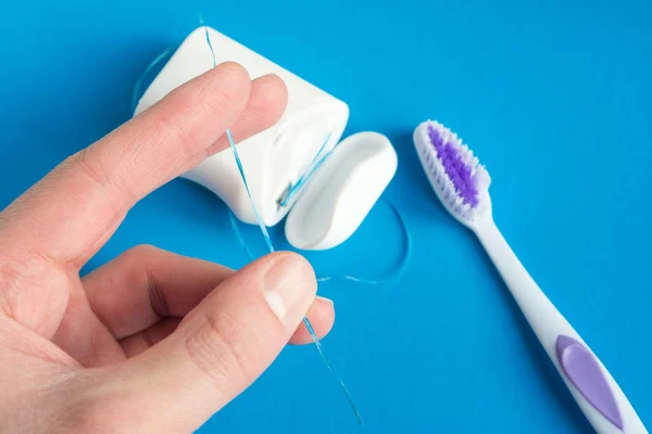 Dental Floss Toothbrush Hand Blue Background Concept Care Oral Cavity — Stock Photo, Image