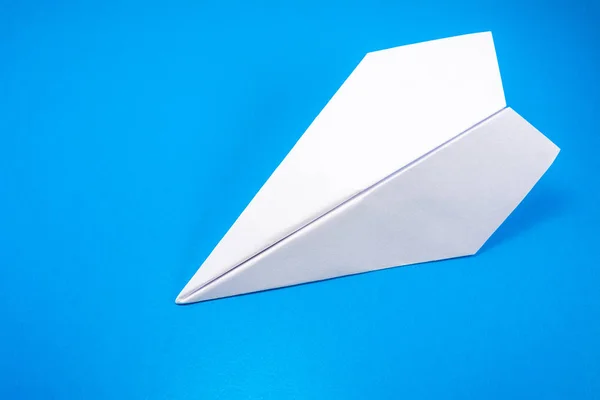 paper airplane made of white paper on a light blue background, copy space, mock up