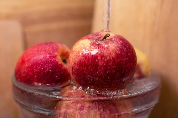 red beautiful juicy ripe apples under running water, the importance of hygiene, washing fruit before eating