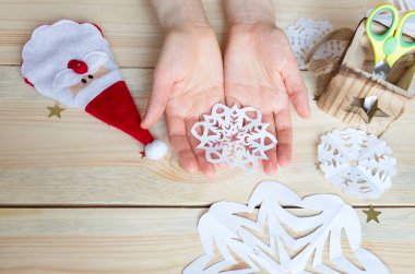 Kız, kağıttan yapılmış ev yapımı kar taneleri yapıyor. Yeni yıla hazırlanıyor. Noel, ev dekorasyonu.