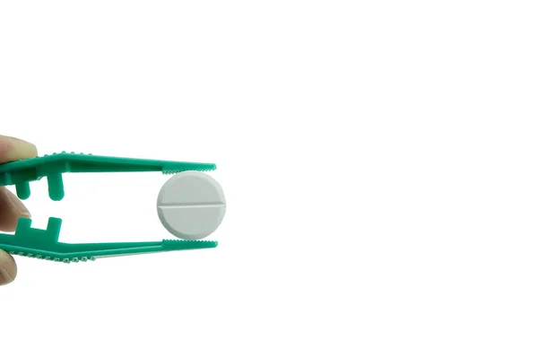 Zielone Plastikowe Pęsety Trzymające Białą Okrągłą Tabletkę Białym Tle — Zdjęcie stockowe