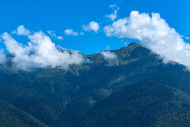 Bulutlardaki yeşil dağların tepeleri, dağlardaki manzaralı manzaralar