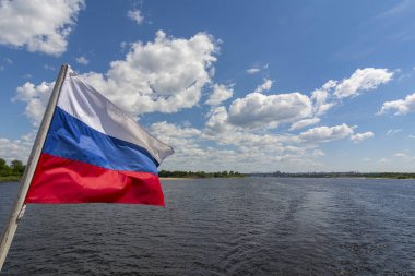 Russian national flag tricolour, white blue red, against the blue sky