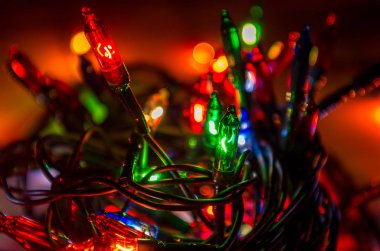 Karanlık bir odada Noel çelengi ışıkları, yanan ampuller, kış Noel havası.