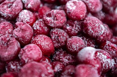 Buzda donmuş kiraz kırmızısı arka plan ve kar taneleri.