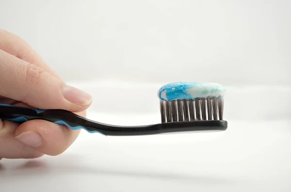 Black Toothbrush Minty Color Toothpaste Girl Hand Light Background — Stock Photo, Image