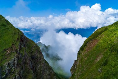 Bulutlardaki yeşil dağların tepeleri, dağlardaki manzaralı manzaralar