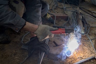 Kaynak makinesinin işi kaynak makinesinin elinde kaynak kıvılcımları, endüstriyel arka plan