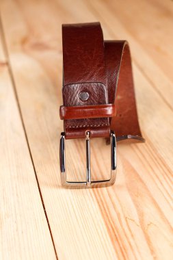 Ahşap arka planda deri pantolon kemeri.