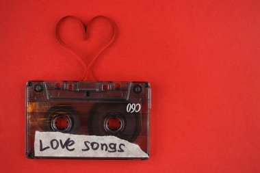 vintage old film music cassette on a trendy red background with the inscription love song, background music, music lovers, heart
