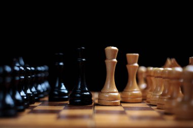placed chess pieces on a dark background, the concept of confrontation, fair and unfair play, political games, rivalry in business