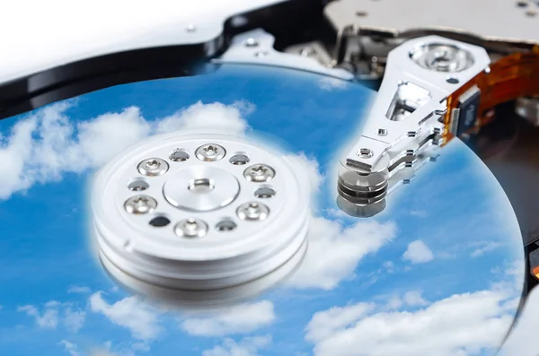 disassembled hard drive with the backdrop of clouds, the concept of cloud storage on white background, hdd, hard disk drive, close-up