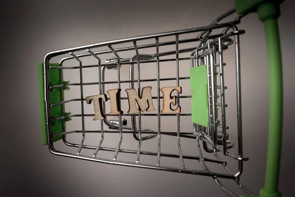 shopping cart with the inscription time lined with letters, the concept of a for a limited and valuable time, money can not buy the time