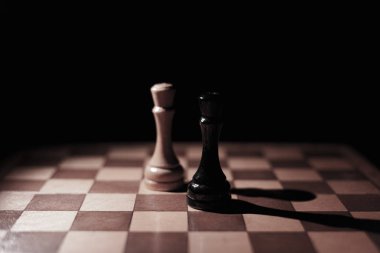 placed chess pieces on a dark background, the concept of confrontation, fair and unfair play, political games, rivalry in business