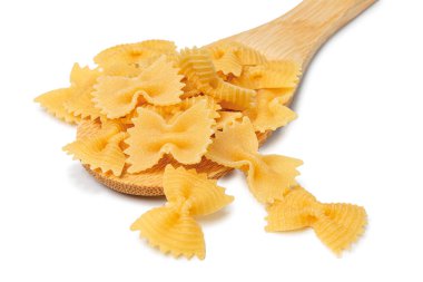 Farfalle buğdayından makarna, yay, hazırlıksız, beyaz arka planda kaşıkta el yapımı çiğ makarna izole edilmiş