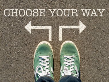 Spor ayakkabılarının tepesindeki fotoğraf ve yazıt asfaltta yolunuzu, serbest seçim konseptini, hareket yönünü, yaşamın felsefi sorusunu seçiniz.