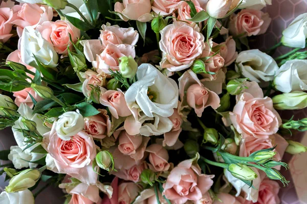 a bouquet of a variety of beautiful flowers like shrub roses and lisianthus eustoma on a wooden surface in nature