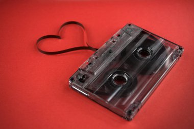 vintage old film music cassette on a trendy pink red background with film heart shaped, background music, music lovers