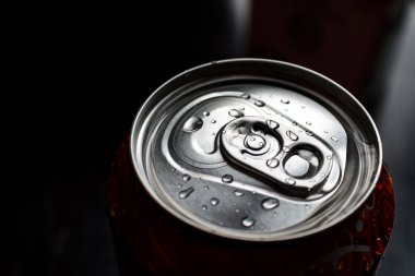 Alüminyum soda ve bira kutusu. Su damlacıkları koyu arka planda, metal kutuda ve geri dönüşümlü ürünlerde izole edilmiş.